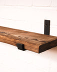 Shou sugi ban effect radiator shelf with metal hanging brackets showing off the wood grain.