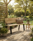 Wooden bench with cushions on a wooden deck surrounded by plants and garden furniture.