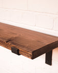 Dark wood shelf with metal brackets
