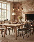 Dining room with wooden table and chairs, brick wall, and fireplace.