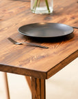 Wooden table with a black plate and fork on a neutral background Flamed finish