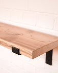Hand sanded scaffold board shelf with propped metal brackets