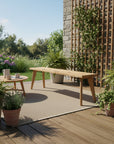 Outdoor patio with wooden table, chairs, and potted plants on a wooden deck.