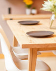 Wooden dining table with white chairs and decorative elements in a room.