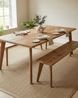 Scaffold Board dining table with benches in a bright room with plants