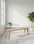 Scaffold Board Wooden bench in a modern room with large windows and a plant.