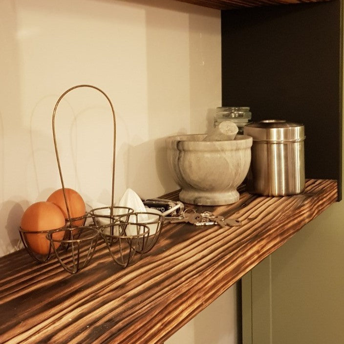 Charred scaffold board used as shelf in kitchen