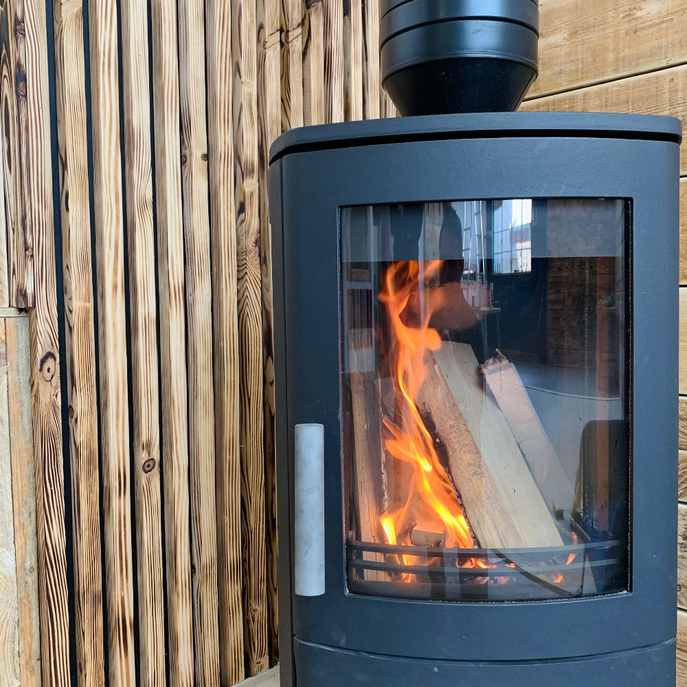 Stunning visual of a woodburner in front of scaffold board cladding from The Scaff Shop