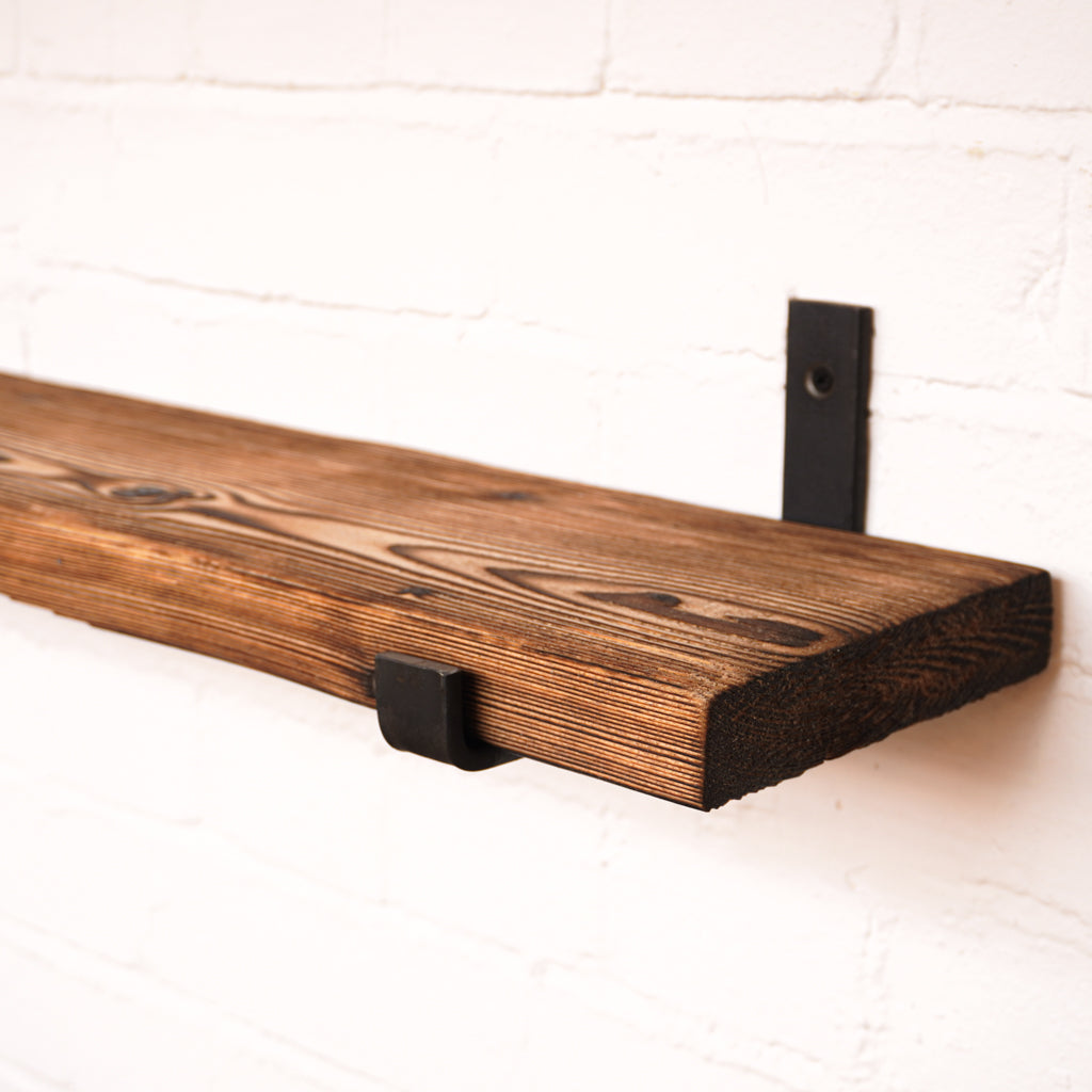 Shou sugi ban effect radiator shelf with metal hanging brackets showing off the wood grain.