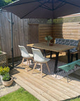 Outdoor timber table with black legs on a wooden decking area
