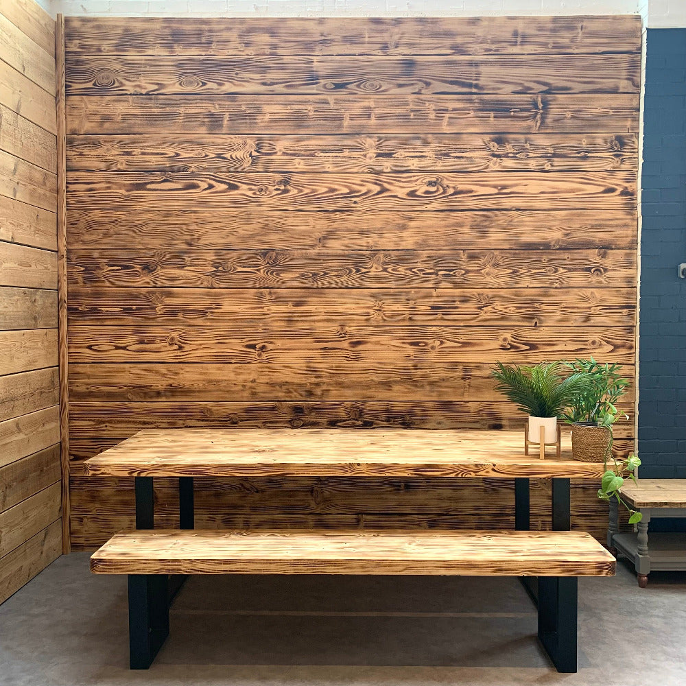 Scorched scaffold boards stacked on a wall as stunning cladding